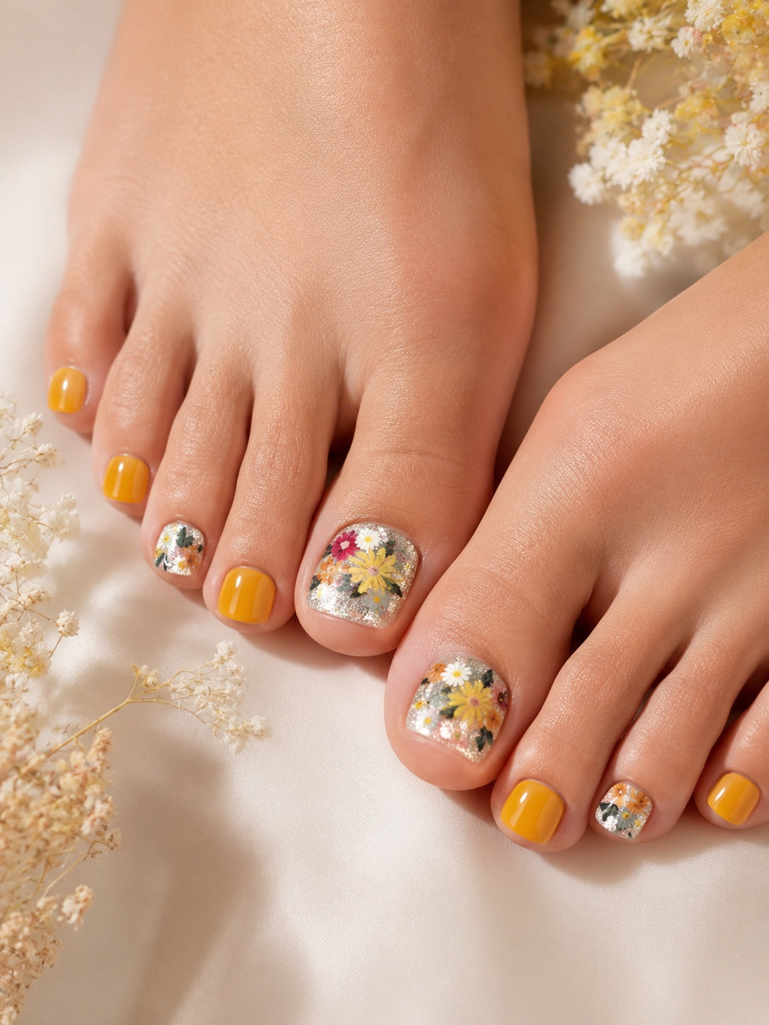 Golden yellow and pressed wildflower press-on toenails modeled on feet
