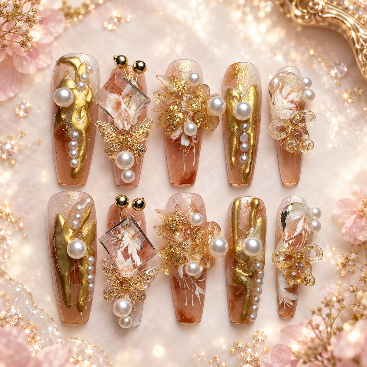 Long coffin nude press-on nails with gold, pearl, butterfly, floral and crystal embellishments