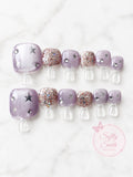 Sheer lavender press-on toe nails with silver stars, rhinestones, and glitter accents