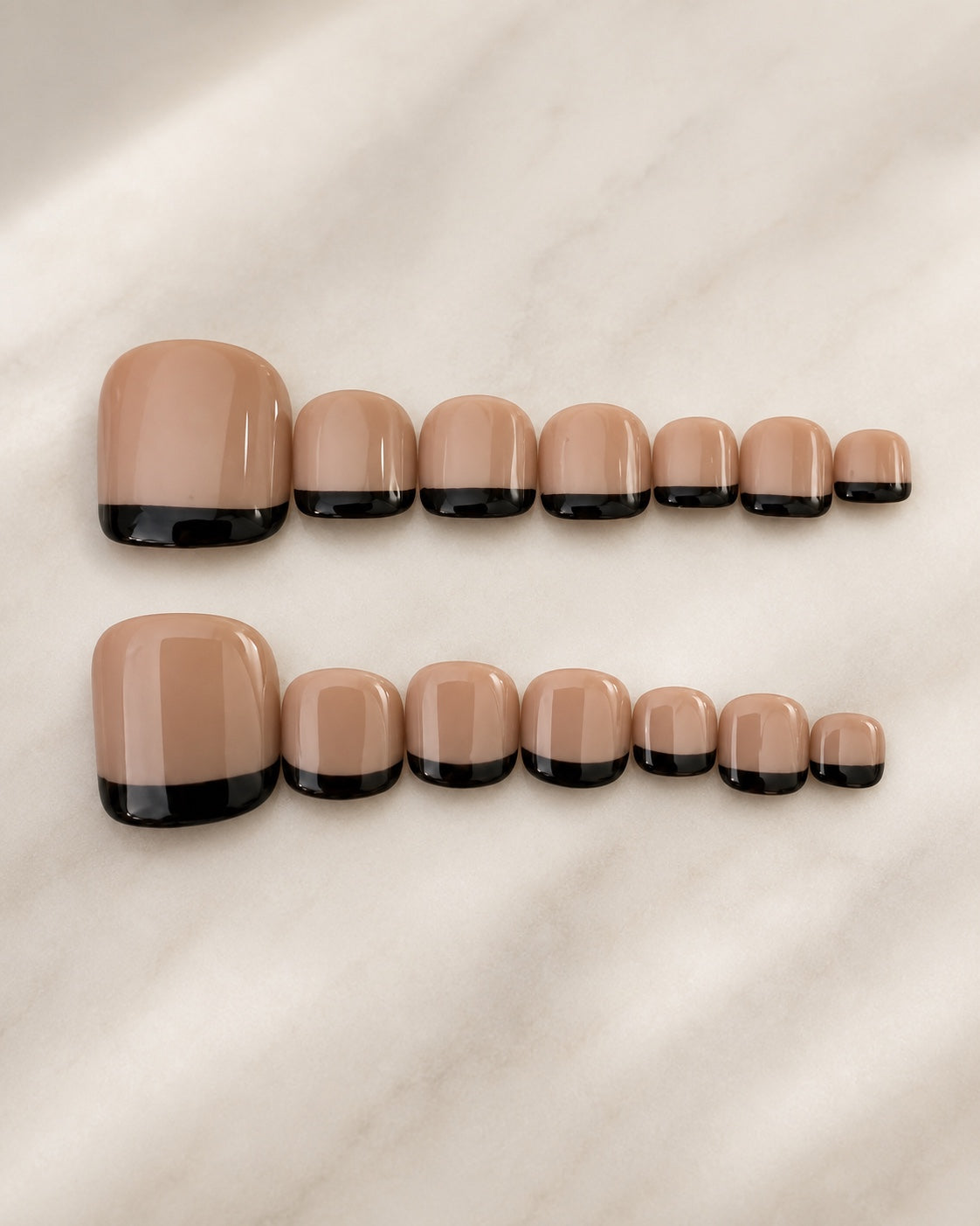 Nude press-on toenails with black French tips