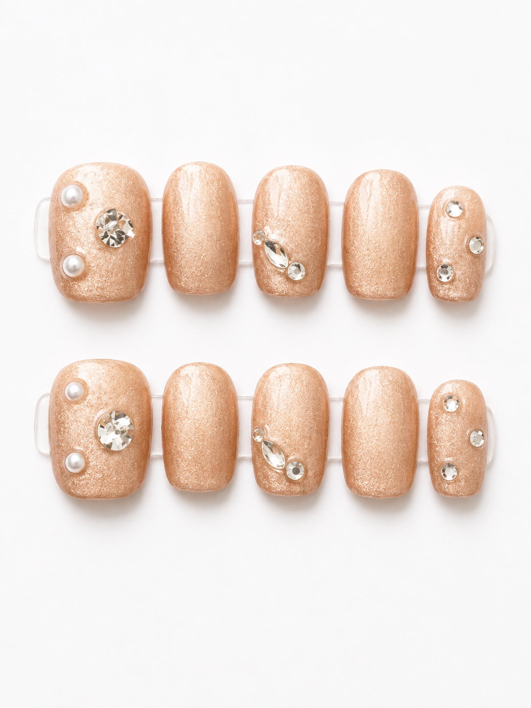 Small champagne shimmer press-on nails with pearl and rhinestone accents