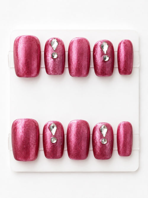 Small hot pink shimmer press-on nails with crystal rhinestone accents